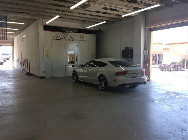 A vehicle beside the paint booth inside Ability’s workshop